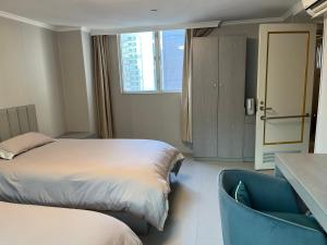 a hotel room with a bed and a chair at 皇后超級管家 in Hong Kong