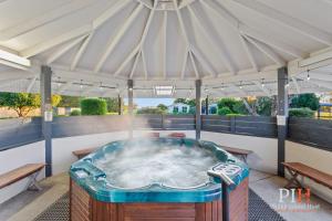 a hot tub in a tent with two benches at Phillip Island Family Resort 2Bdr in Cowes