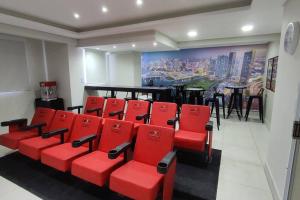 een groep rode stoelen in een kamer met een schilderij bij Lindo e aconchegante Stúdio mobiliado - Centro in Araraquara