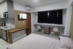 een slaapkamer met een bed, een wastafel en een televisie bij Lindo e aconchegante Stúdio mobiliado - Centro in Araraquara
