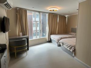 a hotel room with two beds and a window at 皇后超級管家 in Hong Kong