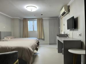 a hotel room with a bed and a desk and a television at 皇后超級管家 in Hong Kong