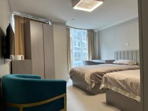 a hotel room with two beds and a blue chair at 皇后超級管家 in Hong Kong