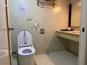 a bathroom with a toilet with the lid up at 皇后超級管家 in Hong Kong