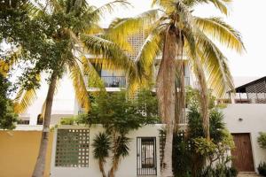 a building with palm trees in front of it at Hotel boutique 1A Lomas Sense in Mazatlán