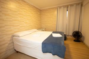 a bedroom with a large white bed in a room at Aconchego da Helô 03 in Mariana
