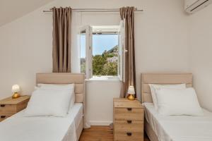 two beds in a room with a window at All'oro in Njivice