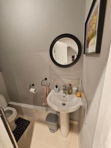 a bathroom with a white sink and a mirror at Hillsome Hosting Wigan in Pemberton