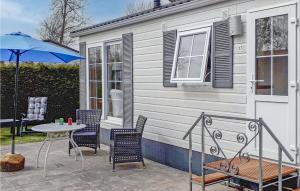 a patio with a table and chairs and an umbrella at Lovely Home In Tzummarum With Wifi in Tzummarum