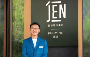 昆明昆明JEN酒店的一名身穿蓝色西装的男子站在标志牌前 更多35张照片