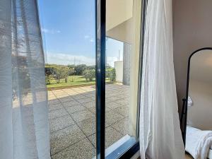 a sliding glass door with a view of a patio at Appartement moderne avec terrasse et parking, au cœur de Granville, à deux pas de la plage ! - FR-1-361-77 in Granville