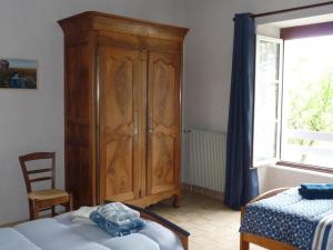 a bedroom with a wooden cabinet next to a bed at Maison avec jardin clos et terrasse couverte en Touraine, proche des châteaux et nature préservée. - FR-1-381-574 in Manthelan