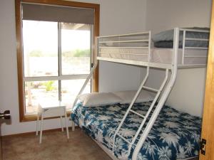 a bedroom with two bunk beds and a window at Beach Front Blue in Coobowie