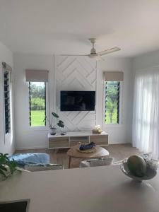 a living room with a couch and a tv at Konini Retreat in Rarotonga