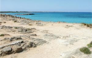 einen Strand mit Felsen und dem Ozean im Hintergrund in der Unterkunft Nice Home In Carovigno Br With Wifi in Carovigno