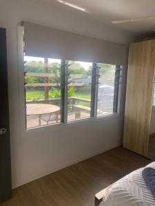 a bedroom with a bed and a window with a balcony at Konini Retreat in Rarotonga