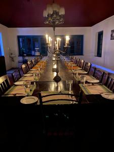 a long dining room with a long table with chairs at Sir John's Bungalow in Matale