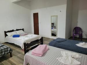 a room with two beds and a mirror at Pousada Suítes continental in Salinópolis +21 photos