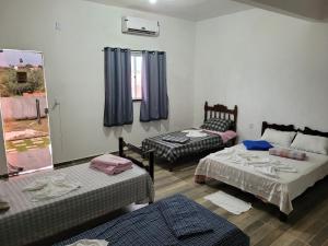 a living room with two beds and a window at Pousada Suítes continental in Salinópolis