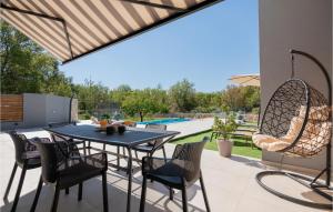 a patio with a table and chairs and a pool at Gorgeous Home In Katuni With Wifi in Katuni