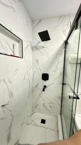 Un baño con ducha con paredes de mármol blanco. en Modern 2BR Stylish & Cozy Unit, en Los Ángeles