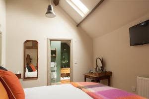 ウッドストックにあるKillingworth Castleのベッドルーム1室(ベッド1台、壁掛けテレビ付)