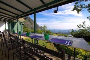 a table with chairs and a view of a mountain at Sir John's Bungalow in Matale