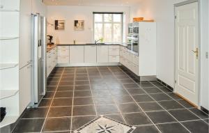 a kitchen with white cabinets and a tiled floor at Seven-Bedroom Holiday Home In Bredebro in Bredebro