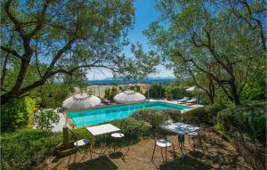 a pool with chairs and umbrellas in a yard at Beautiful Apartment In Lamporecchio in Lamporecchio