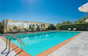 a swimming pool with blue water in a yard at Beautiful Apartment In Lamporecchio in Lamporecchio +14 photos