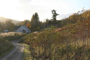 a dirt road leading to a house on a hill at BCC Loch Ness Hostel in Bearnock