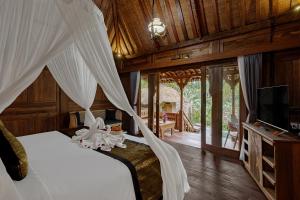 ウブドにあるBubu Mesari Ubud Villaのベッドルーム(白い蚊帳付きのベッド1台付)