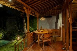ウブドにあるBubu Mesari Ubud Villaの木製のポーチ(テーブル、椅子付)