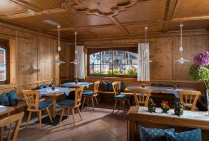 a restaurant with tables and chairs and a window at Garni Aritz in Campitello di Fassa