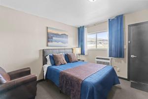 a bedroom with a bed and a couch and a window at Lost Trail Resort in Lava Hot Springs