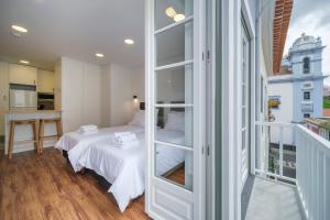 Una pequeña habitación con una cama y una ventana. en Azimute 2, en Angra do Heroísmo