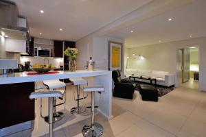 a kitchen and living room with a bar and a couch at 129 on Kloof Nek Apartments in Cape Town