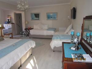 - une chambre avec 2 lits et une table avec des bougies bleues dans l'établissement Twilight Cottage, à Plettenberg Bay