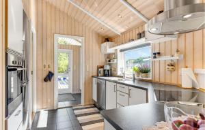 VestergårdにあるHoliday Home Toftlund With A Fireplace 01のキッチン(ウッドパネル付)、大きな窓