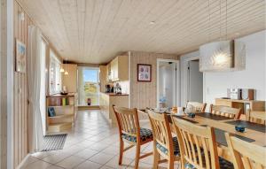 a kitchen and dining room with a table and chairs at Holiday Home Bjerregårdsvej Hvide Sande Denm in Bjerregård