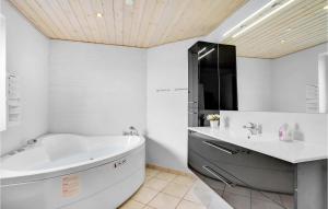 a white bathroom with a tub and a sink at Holiday Home Bjerregårdsvej Hvide Sande Denm in Bjerregård +16 photos