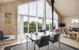 a dining room with a table and chairs and windows at Holiday Home Jordbærvej Tarm Iv in Hemmet