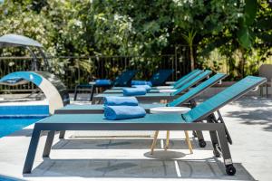 a row of blue lounge chairs next to a pool at All'oro in Njivice