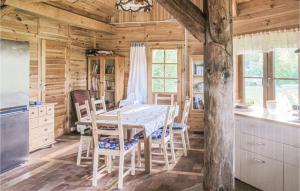 a kitchen and dining room with a table and chairs at Three-Bedroom Holiday Home In Milakowo in Miłakowo