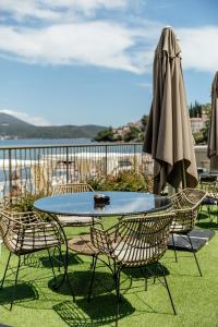 a table and chairs and an umbrella on a balcony at All'oro in Njivice