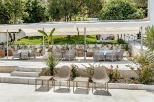 an outdoor patio with tables and chairs and plants at All'oro in Njivice
