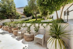 a row of wicker chairs and tables next to a wall at All'oro in Njivice