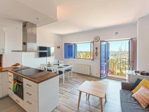 una cucina e un soggiorno con un tavolo di Ático Familiar Renovado Frente al Mar con Terraza y Vistas Panorámicas en Vilanova i la Geltrú - ES-332-2 a Vilanova i la Geltrú