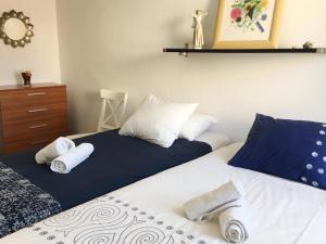 2 letti con asciugamani in una camera da letto di Ático Familiar Renovado Frente al Mar con Terraza y Vistas Panorámicas en Vilanova i la Geltrú - ES-332-2 a Vilanova i la Geltrú