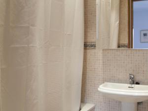 un bagno con tenda da doccia e lavandino di Ático Familiar Renovado Frente al Mar con Terraza y Vistas Panorámicas en Vilanova i la Geltrú - ES-332-2 a Vilanova i la Geltrú Altre 17 foto